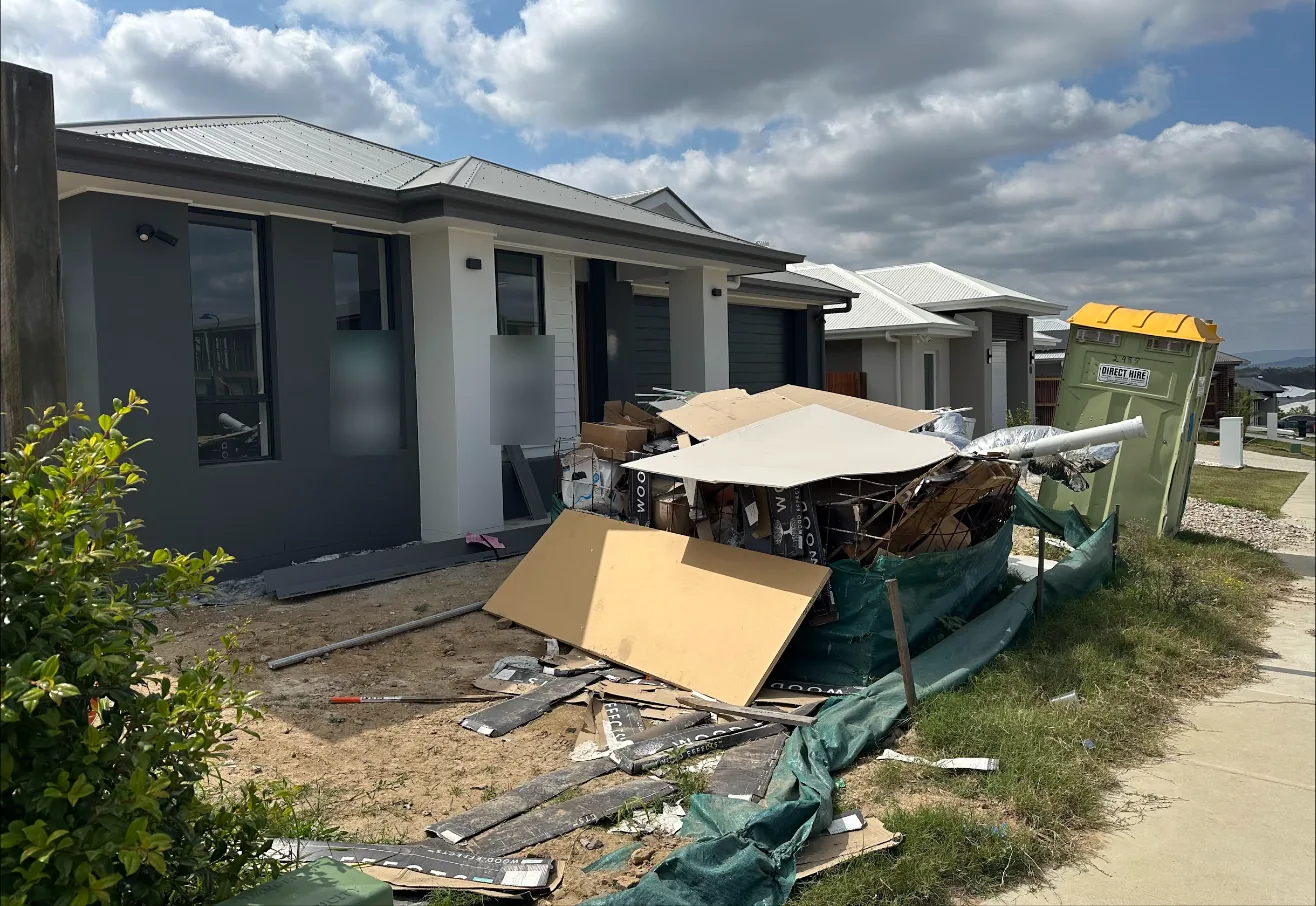 Finished house with builder rubbish piled in front