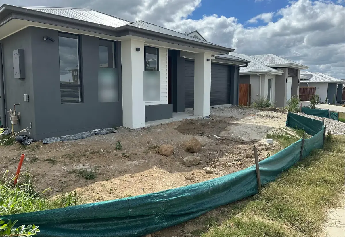 House on handover day, silt fence still up and garden bare
