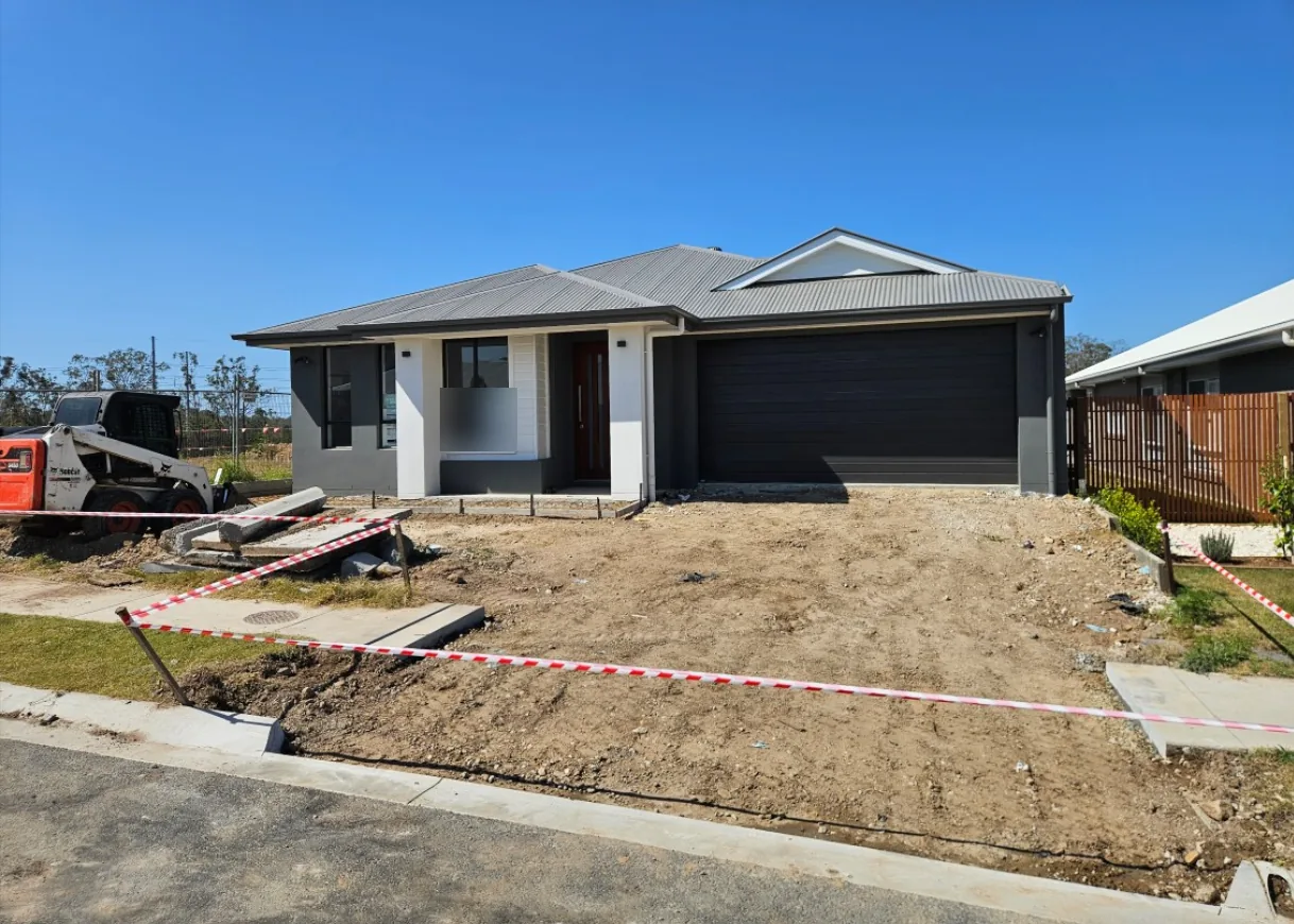 A new house at handover with bare dirt at the front