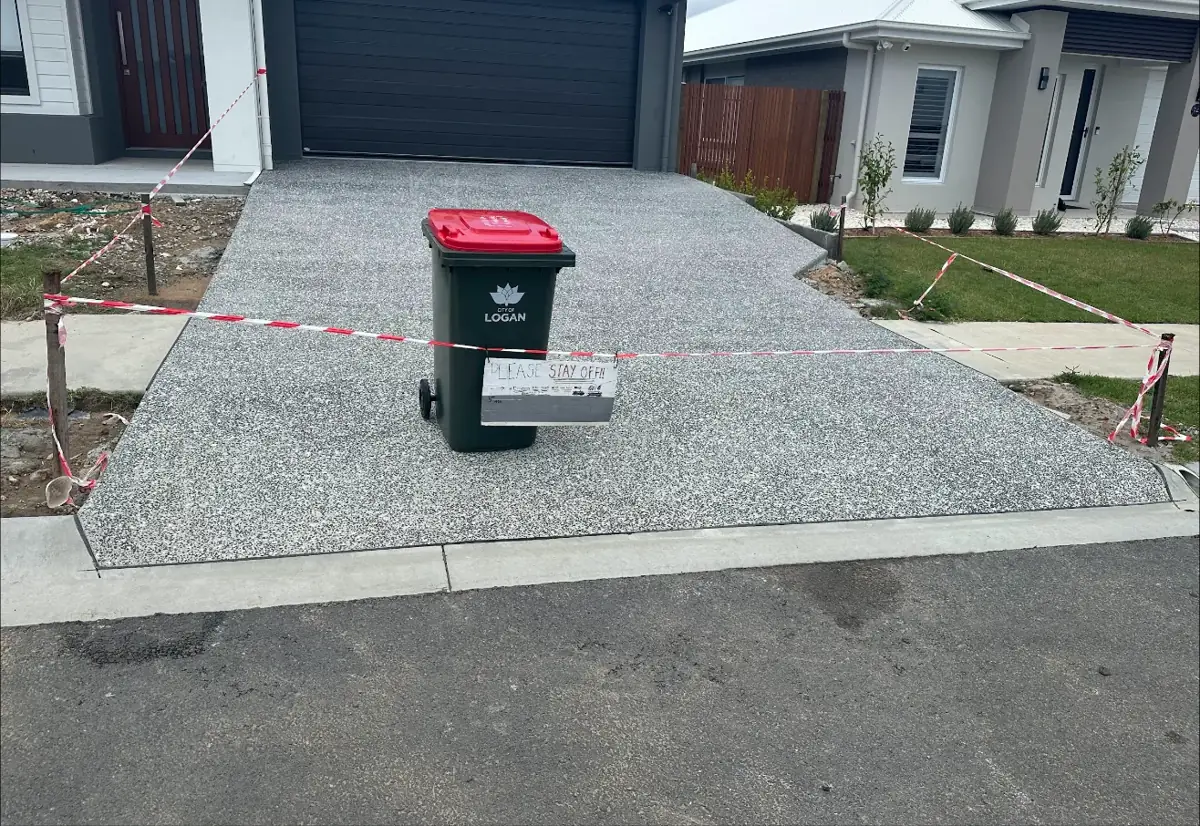 New exposed aggregate driveway taped off while it cures