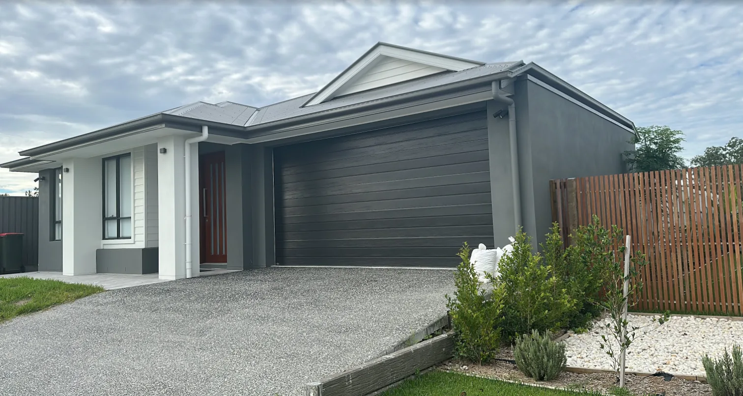 A new house with a finished driveway, garden and fence