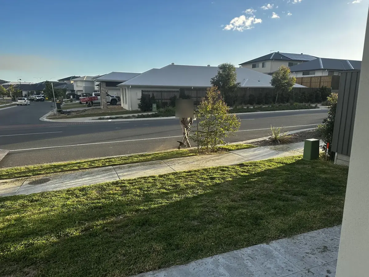 A worker trimming the nature strip edge with a line trimmer