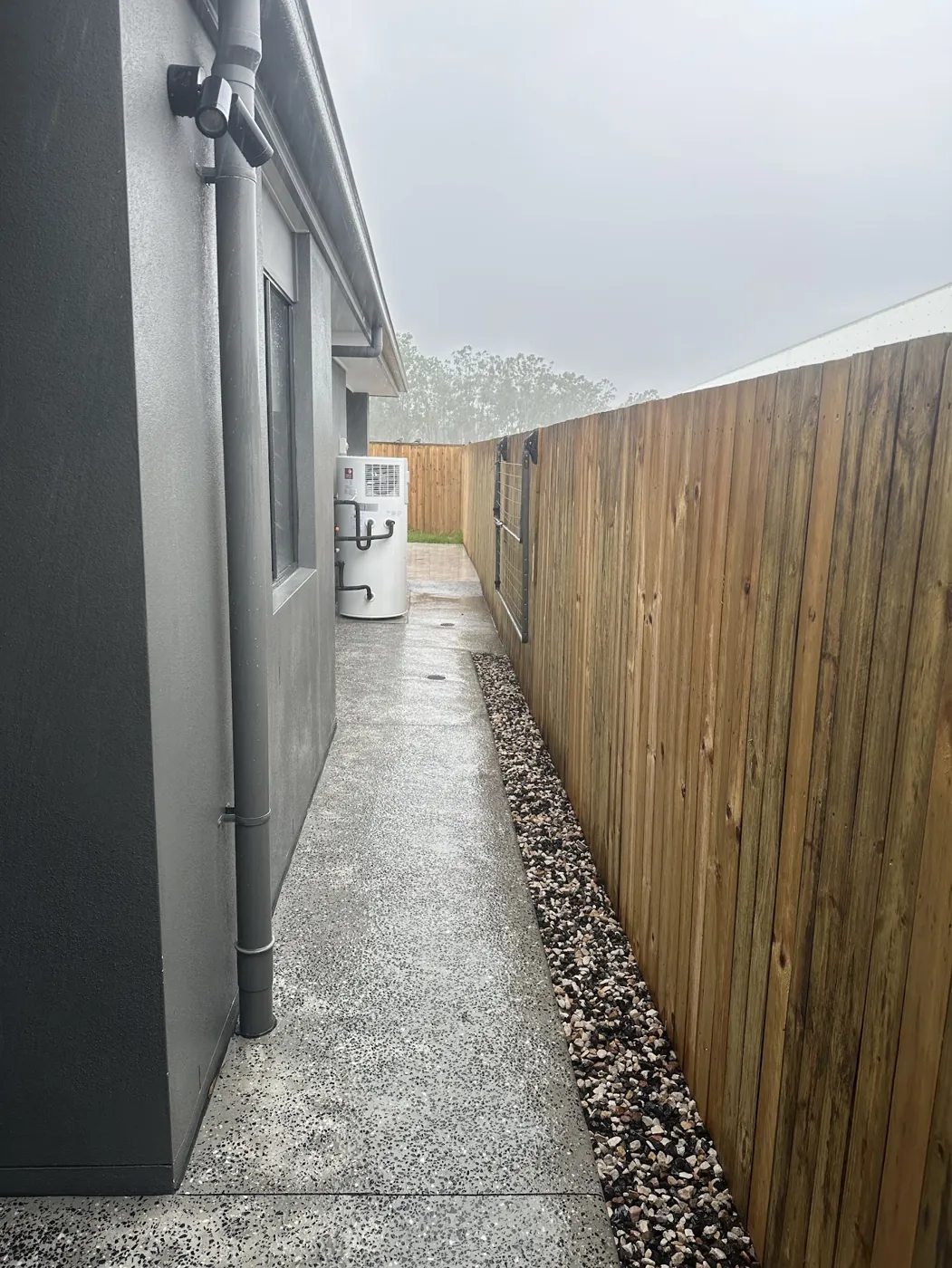 A timber side fence beside a concrete path