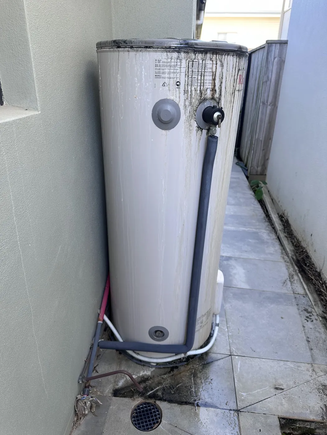 Electric hot water storage tank beside a house