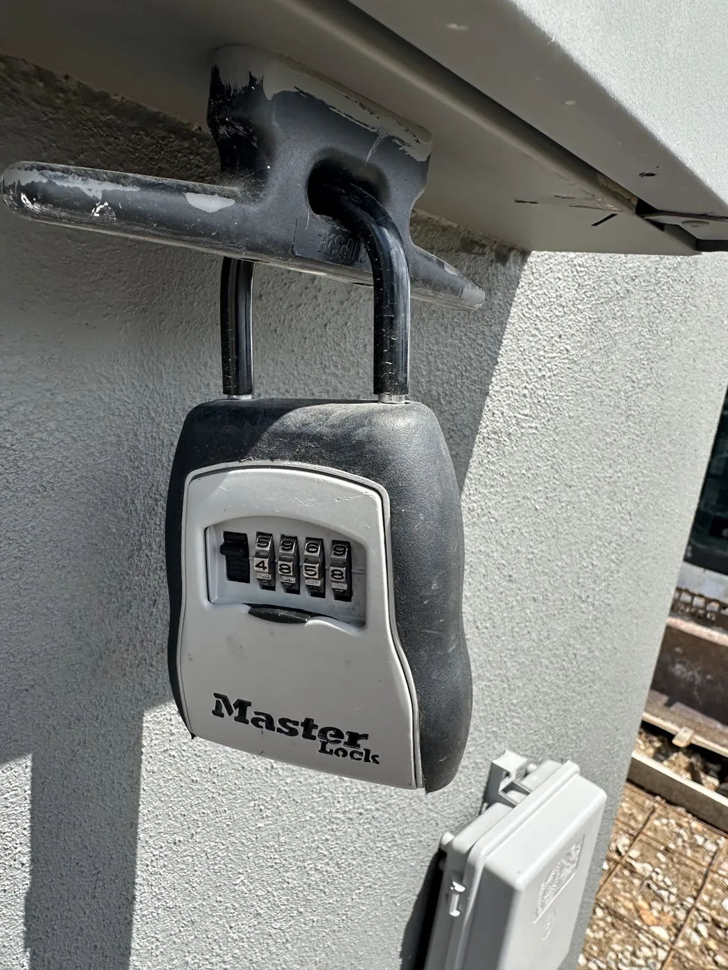 A combination key safe mounted under a meter box